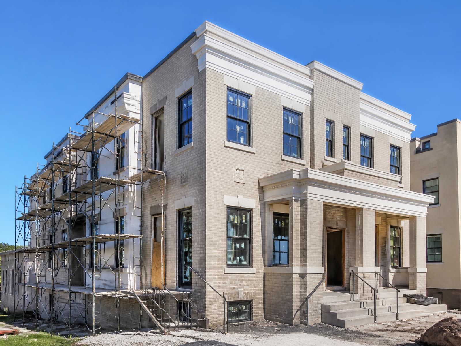 Small multifamily property under renovation on a clear day